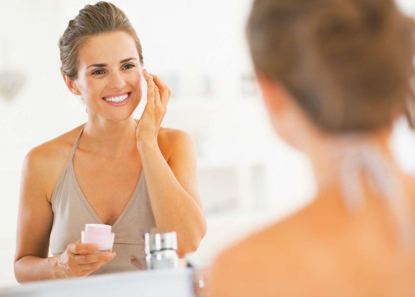 Mulher a colocar creme La Roche Posay ao espelho